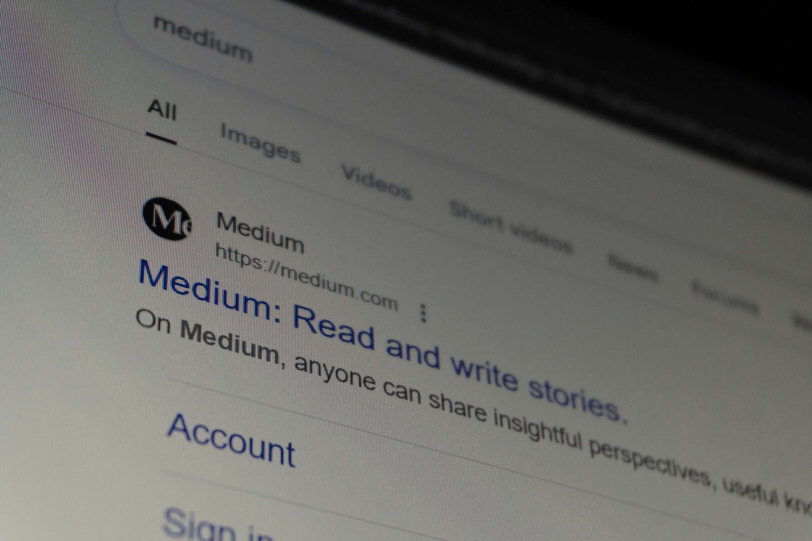 Close-up of a computer screen showing Medium search results page with articles listed.